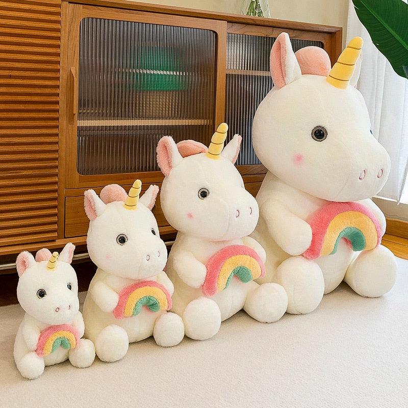 Adorable peluche licorne tenant un arc-en-ciel