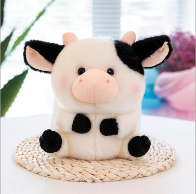 Vache assise en peluche en fourrure