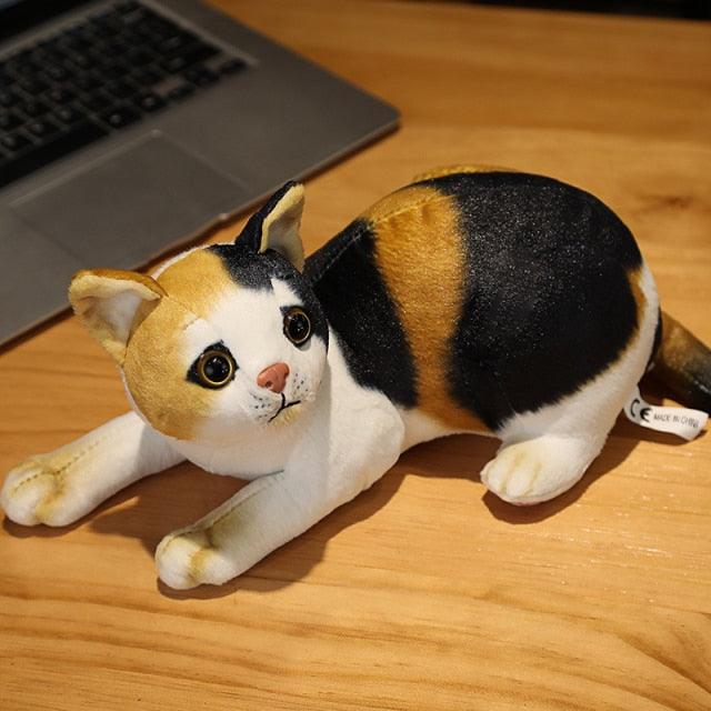 Stuffed animals in the shape of a lying cat