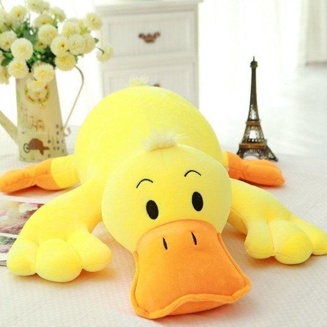 Oreiller en peluche canard jaune couché